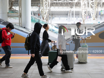 Tourists travel at Nanjing Railway Station in Nanjing, China, on October 1, 2024. (