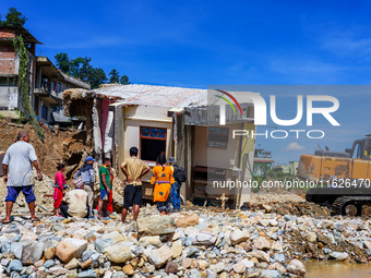 People search for their belongings in damaged houses after Nakhu River flooding in the Tikabhairab region of southern Lalitpur, Nepal, on Oc...