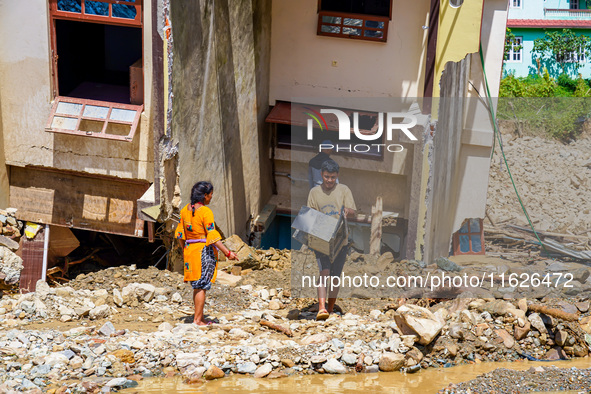 People search for their belongings in damaged houses after Nakhu River flooding in the Tikabhairab region of southern Lalitpur, Nepal, on Oc...