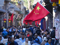 Tourists visit Zhoucun Ancient Shopping Mall decorated with red flags in Zibo, China, on October 1, 2024. (