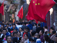 Tourists visit Zhoucun Ancient Shopping Mall decorated with red flags in Zibo, China, on October 1, 2024. (