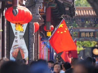 Tourists visit Zhoucun Ancient Shopping Mall decorated with red flags in Zibo, China, on October 1, 2024. (