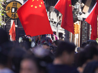 Tourists visit Zhoucun Ancient Shopping Mall decorated with red flags in Zibo, China, on October 1, 2024. (