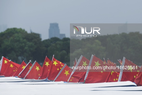 The five-star red flags fly in the wind on the West Lake cruise boat to celebrate the 75th anniversary of the founding of the People's Repub...