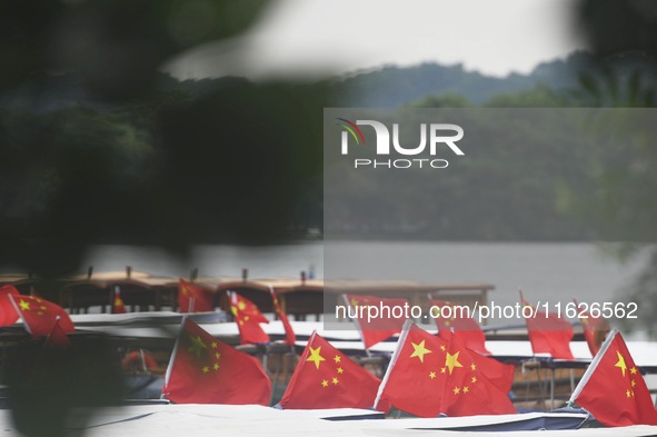 The five-star red flags fly in the wind on the West Lake cruise boat to celebrate the 75th anniversary of the founding of the People's Repub...