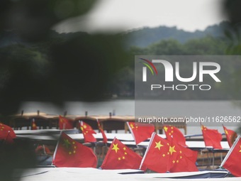 The five-star red flags fly in the wind on the West Lake cruise boat to celebrate the 75th anniversary of the founding of the People's Repub...