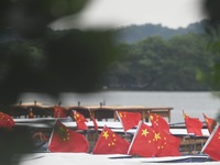 The five-star red flags fly in the wind on the West Lake cruise boat to celebrate the 75th anniversary of the founding of the People's Repub...