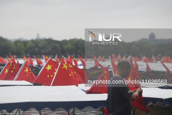 The five-star red flags fly in the wind on the West Lake cruise boat to celebrate the 75th anniversary of the founding of the People's Repub...