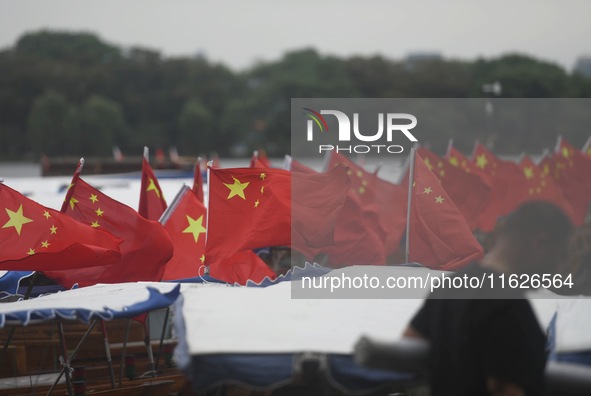 The five-star red flags fly in the wind on the West Lake cruise boat to celebrate the 75th anniversary of the founding of the People's Repub...