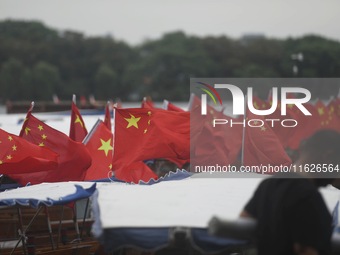 The five-star red flags fly in the wind on the West Lake cruise boat to celebrate the 75th anniversary of the founding of the People's Repub...