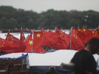 The five-star red flags fly in the wind on the West Lake cruise boat to celebrate the 75th anniversary of the founding of the People's Repub...