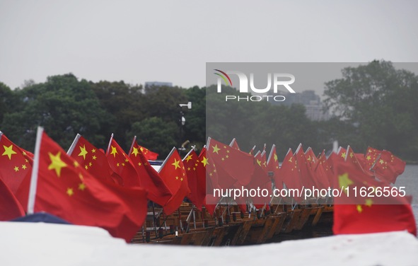 The five-star red flags fly in the wind on the West Lake cruise boat to celebrate the 75th anniversary of the founding of the People's Repub...