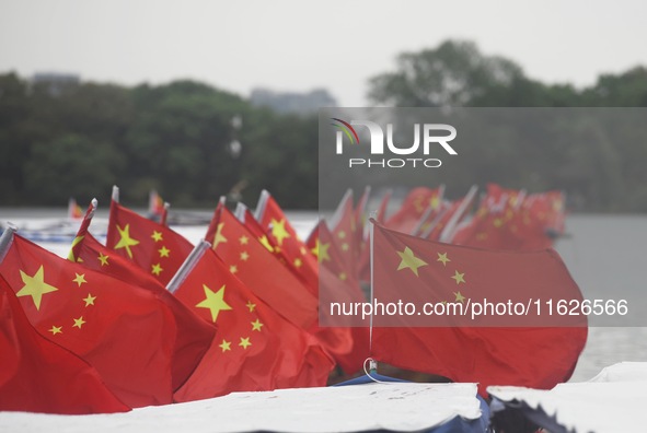 The five-star red flags fly in the wind on the West Lake cruise boat to celebrate the 75th anniversary of the founding of the People's Repub...