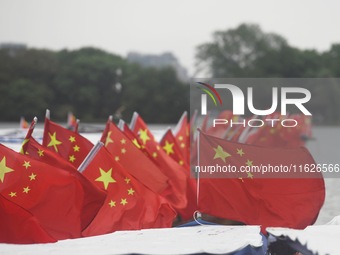 The five-star red flags fly in the wind on the West Lake cruise boat to celebrate the 75th anniversary of the founding of the People's Repub...