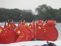 The five-star red flags fly in the wind on the West Lake cruise boat to celebrate the 75th anniversary of the founding of the People's Repub...