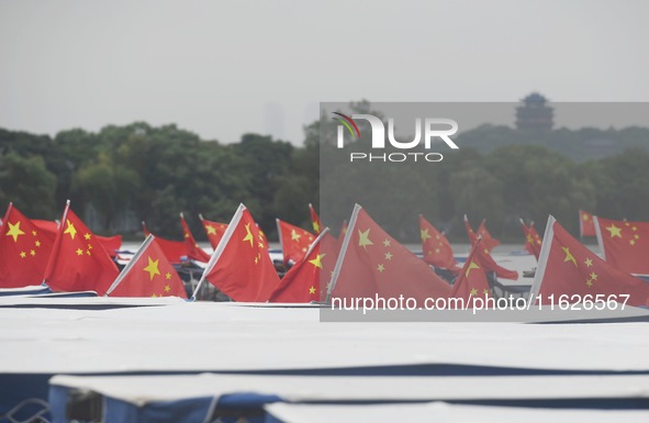 The five-star red flags fly in the wind on the West Lake cruise boat to celebrate the 75th anniversary of the founding of the People's Repub...