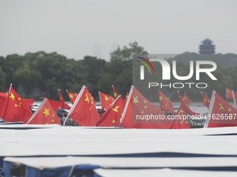 The five-star red flags fly in the wind on the West Lake cruise boat to celebrate the 75th anniversary of the founding of the People's Repub...