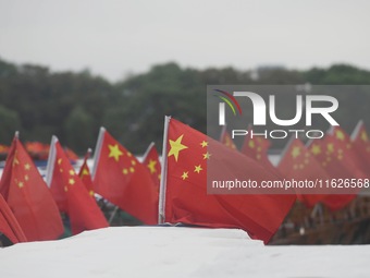 The five-star red flags fly in the wind on the West Lake cruise boat to celebrate the 75th anniversary of the founding of the People's Repub...