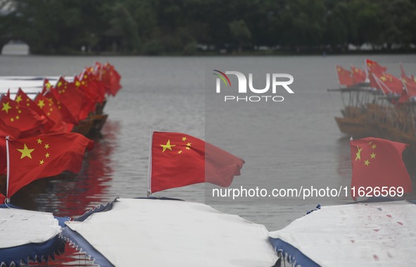 The five-star red flags fly in the wind on the West Lake cruise boat to celebrate the 75th anniversary of the founding of the People's Repub...