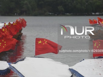 The five-star red flags fly in the wind on the West Lake cruise boat to celebrate the 75th anniversary of the founding of the People's Repub...