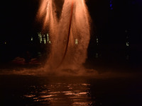 A folk artist dressed in fire-proof clothing puts burned charcoal into an iron net on both sides and shakes the net to create fireworks in F...