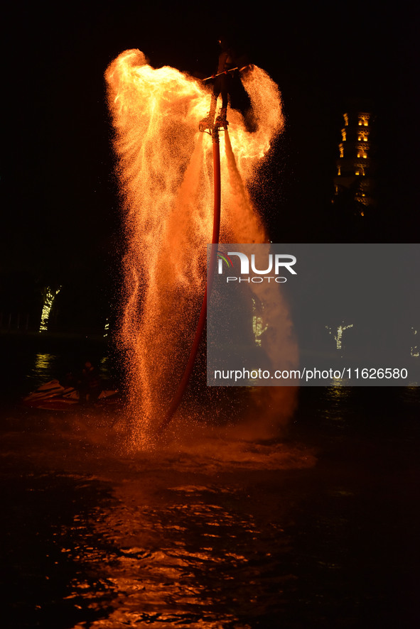 A folk artist dressed in fire-proof clothing puts burned charcoal into an iron net on both sides and shakes the net to create fireworks in F...