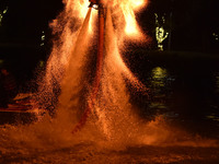 A folk artist dressed in fire-proof clothing puts burned charcoal into an iron net on both sides and shakes the net to create fireworks in F...