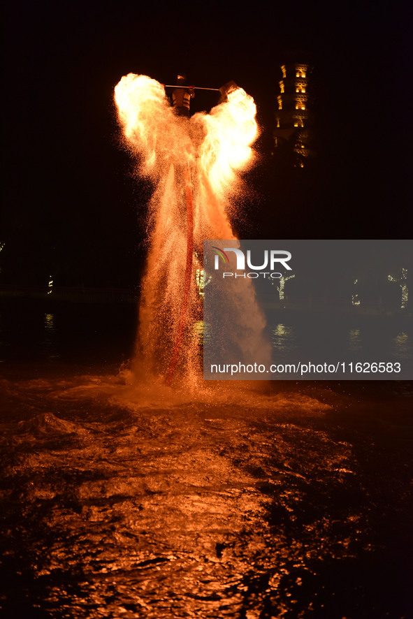 A folk artist dressed in fire-proof clothing puts burned charcoal into an iron net on both sides and shakes the net to create fireworks in F...