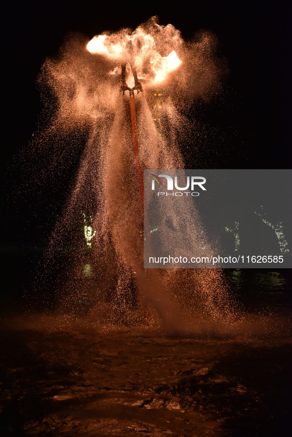 A folk artist dressed in fire-proof clothing puts burned charcoal into an iron net on both sides and shakes the net to create fireworks in F...