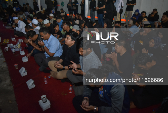 Hundreds of soccer supporters and families of the victims of the Kanjuruhan Stadium disaster hold a joint prayer at Gate 13 of Kanjuruhan St...