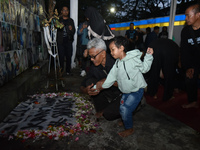 A child holds a poster of his mother with his grandfather during a prayer vigil to mark the second anniversary of the football disaster that...