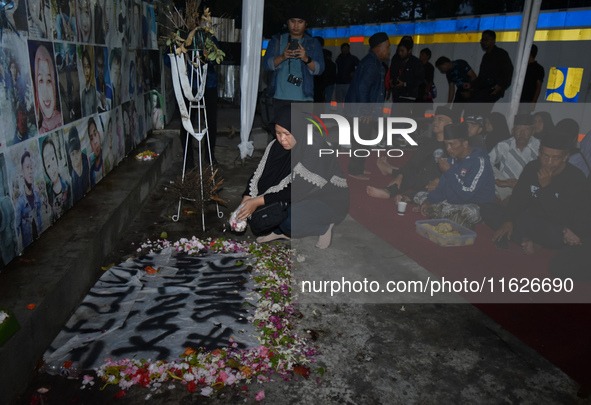 Hundreds of soccer supporters and families of the victims of the Kanjuruhan Stadium disaster hold a joint prayer at Gate 13 of Kanjuruhan St...