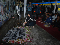 Hundreds of soccer supporters and families of the victims of the Kanjuruhan Stadium disaster hold a joint prayer at Gate 13 of Kanjuruhan St...