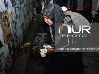 Victims' families cry during a prayer vigil on the second anniversary of the football disaster that kills 135 people on October 1, 2022, at...