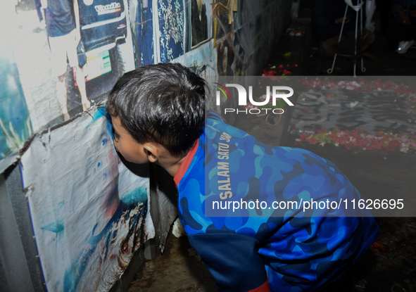 A child kisses a poster of his father during a prayer vigil to mark the second anniversary of the football disaster that killed 135 people o...