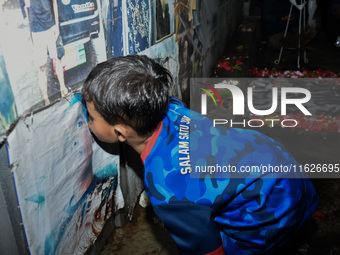 A child kisses a poster of his father during a prayer vigil to mark the second anniversary of the football disaster that killed 135 people o...