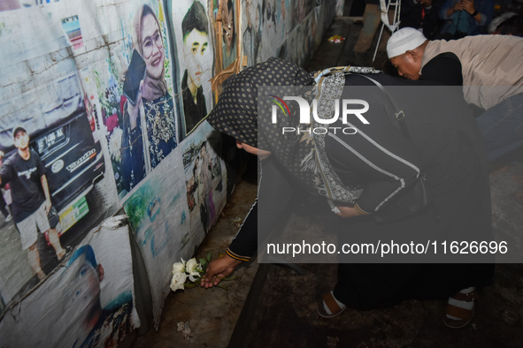 Hundreds of soccer supporters and families of the victims of the Kanjuruhan Stadium disaster hold a joint prayer at Gate 13 of Kanjuruhan St...