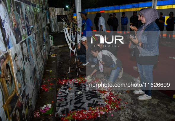 Victims' families cry during a prayer vigil on the second anniversary of the football disaster that kills 135 people on October 1, 2022, at...