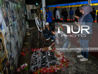 Victims' families cry during a prayer vigil on the second anniversary of the football disaster that kills 135 people on October 1, 2022, at...