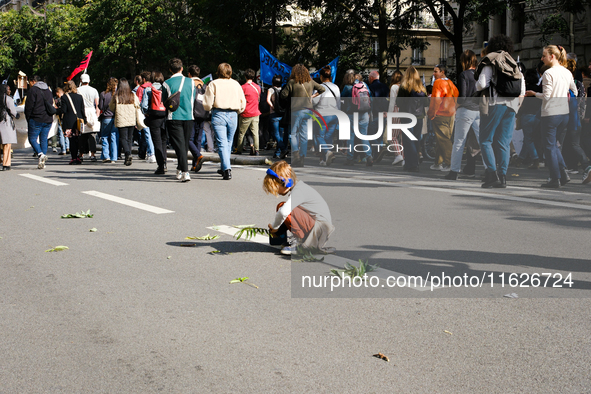 A child plays with leaves in a procession of the demonstration against the policies of Michel Barnier and Emmanuel Macron, in Paris, France,...