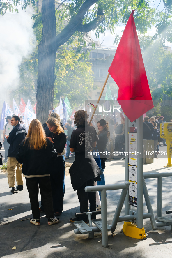 Young demonstrators with a red flag during the interprofessional strike day against the policies of Michel Barnier and Emmanuel Macron, in P...