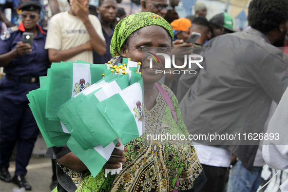 A woman sells Nigerian flags during a protest tagged #FearlessInOctober over increased hunger, insecurity, and economic hardship, as Nigeria...