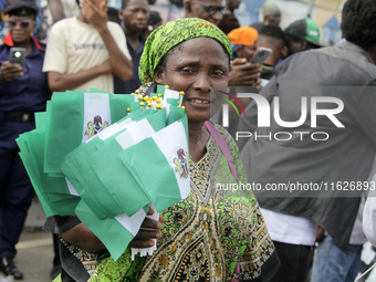 A woman sells Nigerian flags during a protest tagged #FearlessInOctober over increased hunger, insecurity, and economic hardship, as Nigeria...