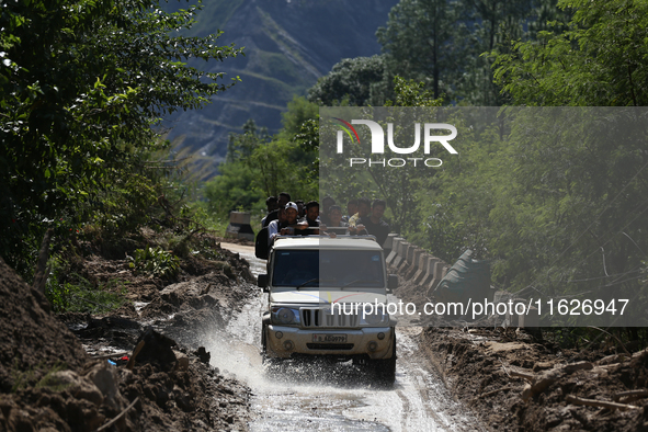 Nepali passengers ride on a jeep as they travel through the partially damaged BP Highway in Kavrepalanchowk District of Central Nepal on Oct...