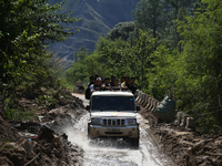 Nepali passengers ride on a jeep as they travel through the partially damaged BP Highway in Kavrepalanchowk District of Central Nepal on Oct...