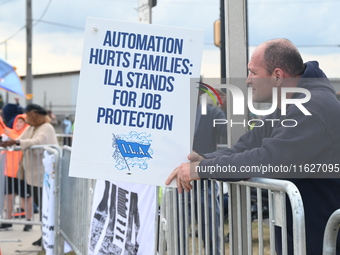 Longshoremen carry signs and demonstrate outside the APM terminals in Elizabeth, New Jersey, United States, on October 1, 2024, as members o...