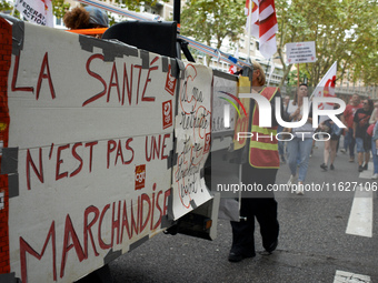 The cardboard on the left reads 'Health isn't a merchandise'. Between 3,000 and 5,000 protesters march in Toulouse, France, on October 1, 20...