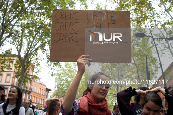 A young woman holds a placard reading 'Order [crossed] Freedom, Equality, Brotherhood'. Between 3,000 and 5,000 protesters march in Toulouse...