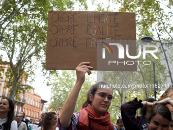 A young woman holds a placard reading 'Order [crossed] Freedom, Equality, Brotherhood'. Between 3,000 and 5,000 protesters march in Toulouse...