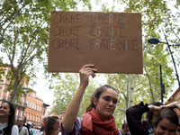 A young woman holds a placard reading 'Order [crossed] Freedom, Equality, Brotherhood'. Between 3,000 and 5,000 protesters march in Toulouse...